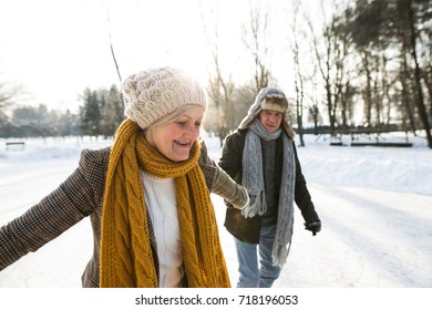 Senior Couple In Sunny Winter Nature Ice Skating.