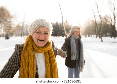 Senior Couple In Sunny Winter Nature On A Walk.