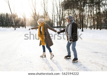 Senior couple in sunny winter nature ice skating.