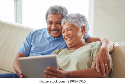 Senior couple, tablet and communication on social media or video call with elderly husband and wife relaxing on the couch at home. Man and woman reading retirement savings insurance on a banking app - Powered by Shutterstock