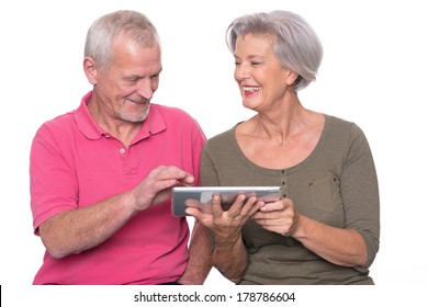 Senior Couple With Tablet Computer In Front Of White Background