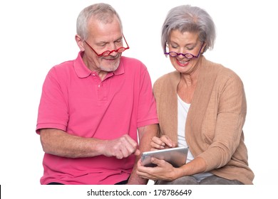 Senior couple with tablet computer in front of white background