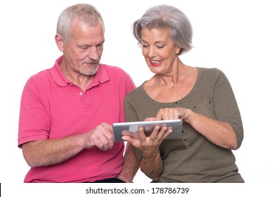 Senior Couple With Tablet Computer In Front Of White Background