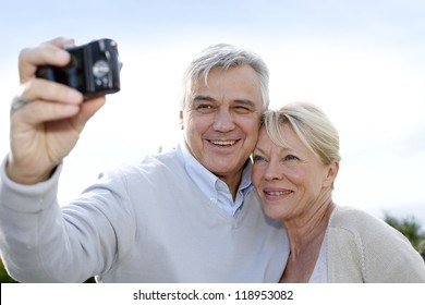 Senior Couple Taking Picture Of Themselves Outside