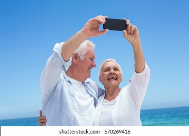 Senior couple taking a selfie at the beach - Powered by Shutterstock