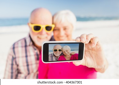 Senior couple taking selfie on the beach - Powered by Shutterstock