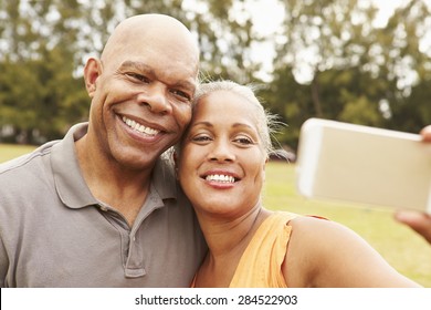 Senior Couple Taking Selfie In Park