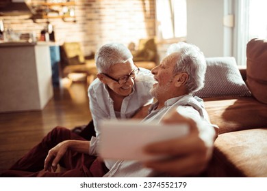 Senior couple taking selfies on a smartphone at home - Powered by Shutterstock