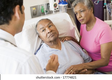 Senior Couple Talking To Doctor,Looking Worried