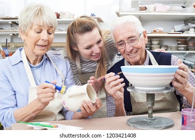 Senior Couple With Teacher In Pottery Class - Powered by Shutterstock