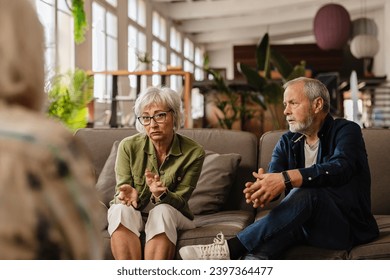 senior couple therapy. Woman arguing with her therapist while husband listens attentively to the couple's relationship problems in front of his psychologist - mental health concept - Powered by Shutterstock