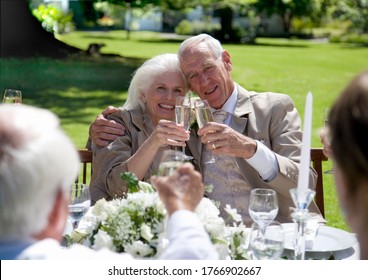 A senior couple toasting with champagne at wedding, parents of the bride or groom - Powered by Shutterstock