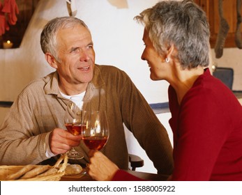 Senior Couple Toasting With Wine In Chalet