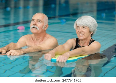 senior couple together in swimming pool - Powered by Shutterstock