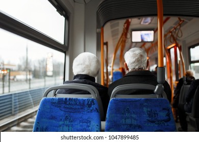 Senior couple travelling on the bus. There are other people sat on the bus who are in the background. - Powered by Shutterstock