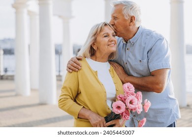 Senior couple in trendy clothes blue and yellow colors Ukrainian symbols the background of the architecture of the old city. People holding hands and walking. Moments that stop time. - Powered by Shutterstock