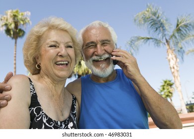 Senior Couple Using Cell Phone Outside