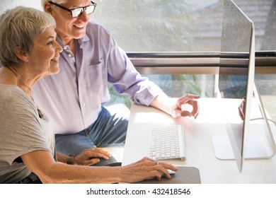 Senior couple using computer, looking at computer screen