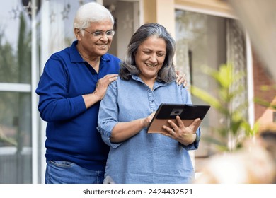 Senior couple using a digital tablet together in their backyard - Powered by Shutterstock