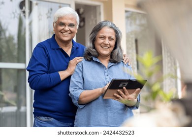 Senior couple using a digital tablet together in their backyard - Powered by Shutterstock