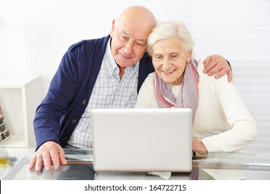 Senior couple using ecommerce in internet with laptop computer - Powered by Shutterstock