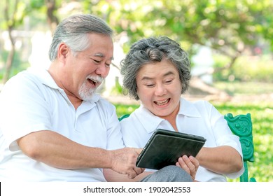 Senior Couple Using A Tablet Phone Computer Face Time Call To Relatives Descendant Relatives Grandchild, Smiling Feel Happy In Parks - Lifestyle Senior Concept