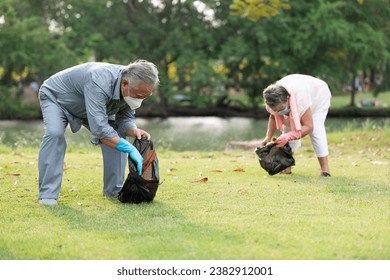 senior couple volunteer wearing face mask holding garbage bag and cleaning in the park - Powered by Shutterstock