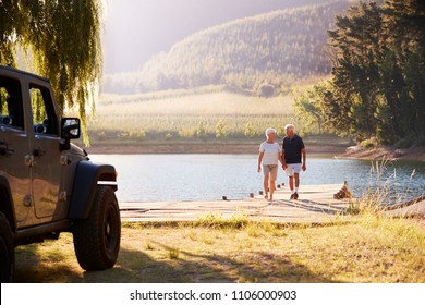 Senior Couple Walking By Lake At The End Of Road Trip - Powered by Shutterstock