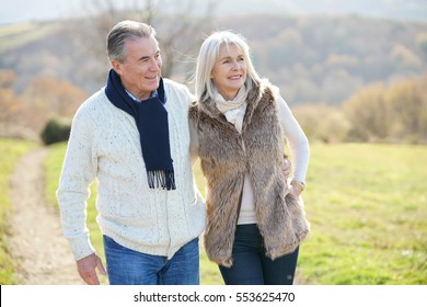 Senior Couple Walking In Countryside On Winter Day