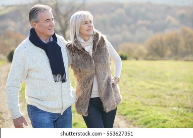 Senior Couple Walking In Countryside On Winter Day