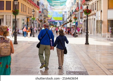 A Senior Couple Walking And Going Sightseeing Around Malaga City, Spain.