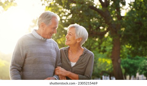 Senior couple, walking and happy outdoor at a park with love, care and support for health and wellness. A elderly man and woman in nature for a walk, quality time and healthy marriage or retirement - Powered by Shutterstock