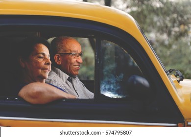 Senior couple walking inside an old car