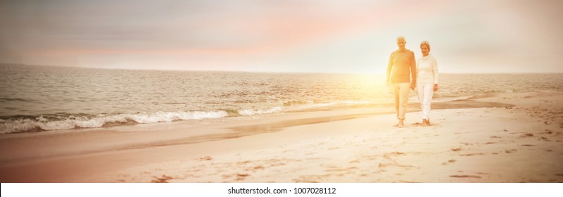 Senior couple walking on the beach on a sunny day
