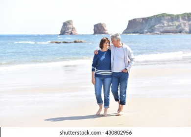 Senior Couple Walking On The Beach