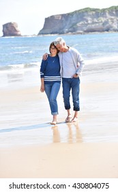 Senior Couple Walking On The Beach