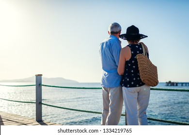 Senior couple walking on pier by Red sea in Egypt. People enjoying summer vacation.