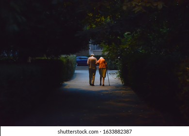 Senior Couple Walking On The Street. View From Behind