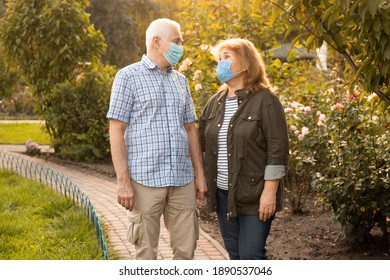 Senior Couple Walking Outside In Nature Wearing Medical Masks