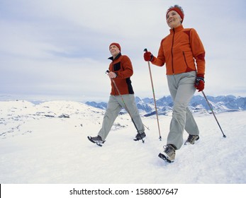 Senior couple walking with ski poles in snow - Powered by Shutterstock