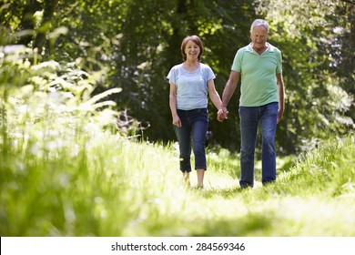 Senior Couple Walking In Summer Countryside