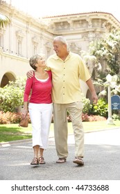 Senior Couple Walking Through City Street