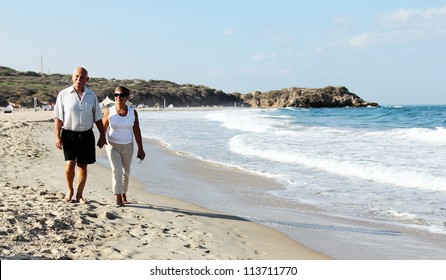 Senior Couple Walking Together On A Beach