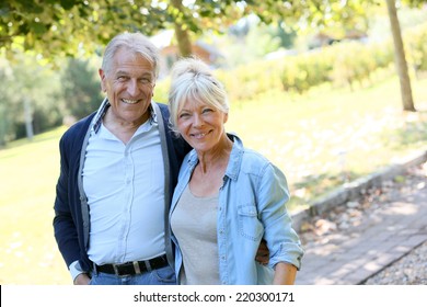 Senior Couple Walking Together In Park