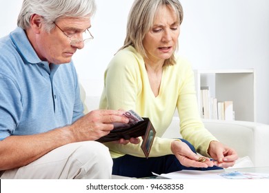 Senior couple with wallet counting Euro money on table at home