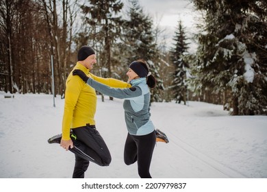 Senior Couple Warming-up In Snowy Forest Before Winter Hike.