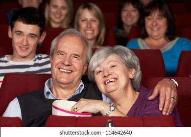 Senior Couple Watching Film In Cinema