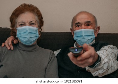 Senior Couple Watching Tv With Face Mask