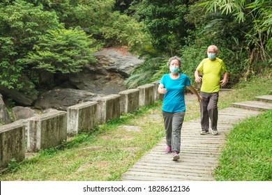 Senior couple wearing face mask and walking trough nature park - Powered by Shutterstock