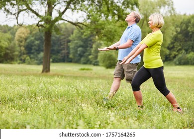 Senior Couple In A Wellness Class Doing A Qi Gong Or Tai Chi Exercise